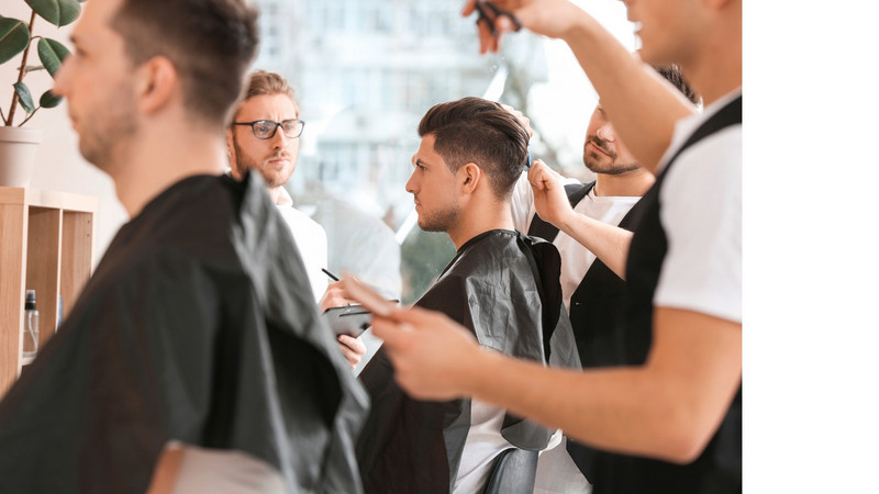 Apprenti coiffeur réalisant une coupe sous la supervision de son tuteur L'apprentissage dans le secteur de la coiffure