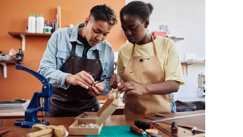 Apprentie maroquinier travaillant le cuir aux côtés de son tuteur La transmission des techniques artisanales par la voie de l'apprentissage
