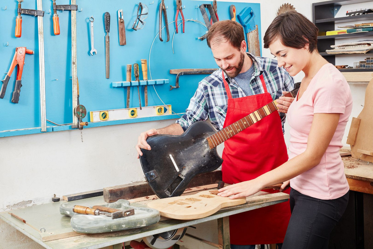 La transmission du savoir-faire en lutherie entre une jeune apprentie et son maître d'apprentissage Apprentie luthier en formation avec son tuteur expérimenté