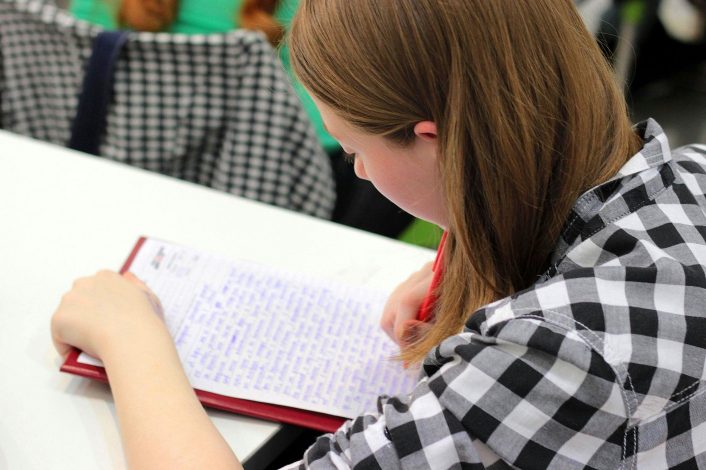 Étudiante concentrée en classe, prenant des notes pendant un cours de BTS. Étudiant en cours de BTS