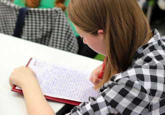 Étudiante concentrée en classe, prenant des notes pendant un cours de BTS. Étudiant en cours de BTS